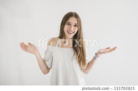 Portrait of teenage girl in casual t-shirt on light background in studio. 131703823