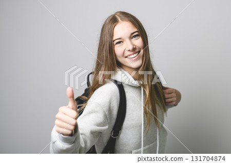 Portrait of teenage student girl in casual t-shirt on light background in studio. 131704874