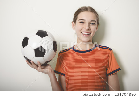 one caucasian young soccer player girl standing in studio gray background 131704880