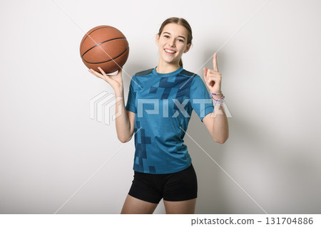 Basketball player holding ball on studio gray background Basketball player holding ball on studio gray background 131704886