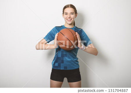Basketball player holding ball on studio gray background Basketball player holding ball on studio gray background 131704887