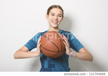 Basketball player holding ball on studio gray background Basketball player holding ball on studio gray background 131704888