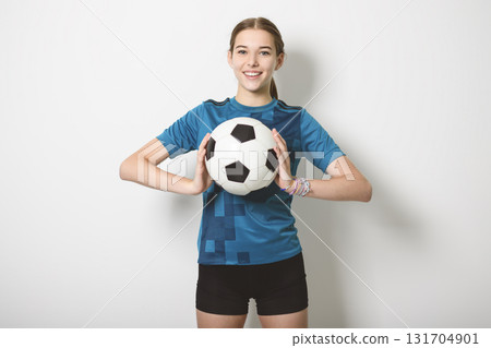 one caucasian young soccer player girl standing in studio gray background 131704901