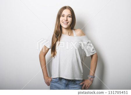 Portrait of teenage girl in casual t-shirt on light background in studio. 131705451