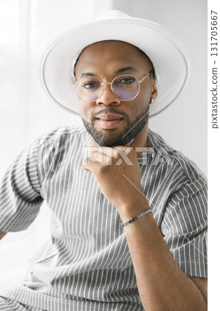Portrait of black fashion American wearing great looking clothes with white hat Portrait of black fashion American wearing great looking clothes with white hat 131705667