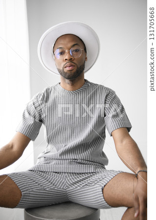 Portrait of black fashion American wearing great looking clothes with white hat Portrait of black fashion American wearing great looking clothes with white hat 131705668