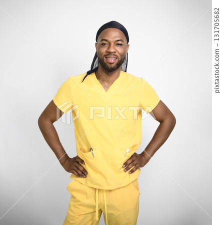 Portrait of a friendly black male nurse wearing yellow scrubs uniform Portrait of a friendly black male nurse wearing yellow scrubs uniform 131705682