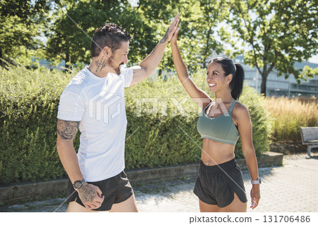 Young fitness couple running on a city on summer day Young fitness couple running on a city on summer day 131706486