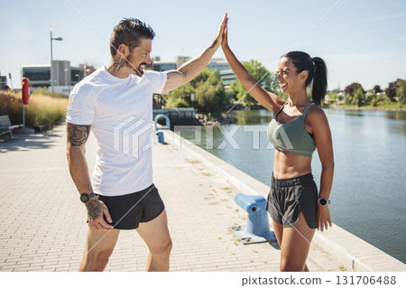 Young fitness couple running on a city on summer day 131706488