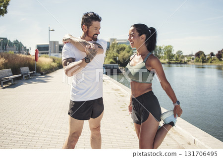 Young fitness couple running on a city on summer day Young fitness couple running on a city on summer day 131706495