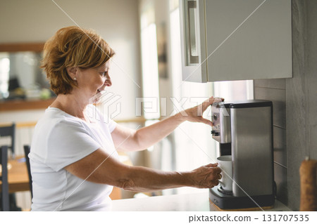 woman making morning coffee smiling, preparing a cup of latte for breakfast woman making morning coffee smiling, preparing a cup of latte for breakfast 131707535