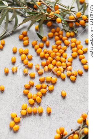 Sea buckthorn berries scattered on gray background 131707778