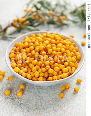 Sea buckthorn berries in bowl with branches 131707781