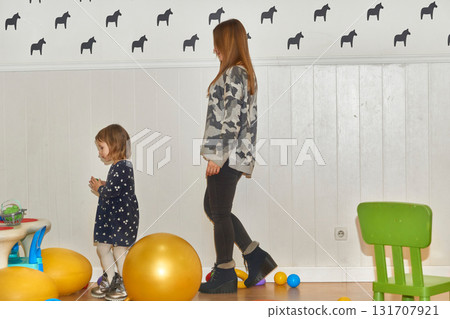 Cute mother and daughter playing in the children's room Cute mother and daughter playing in the children's room 131707921