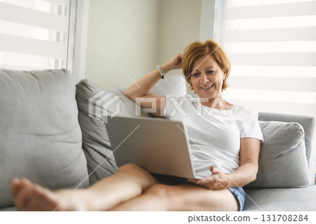 Happy modern European senior woman using laptop Happy modern European senior woman using laptop 131708284