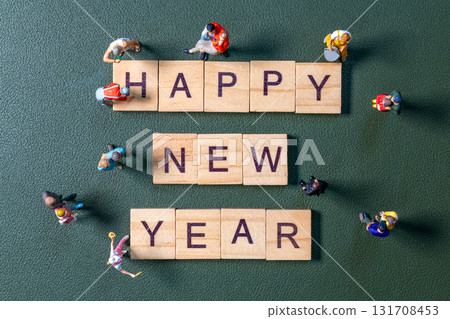 Miniature figurines surrounding wooden letter tiles forming the phrase Happy New Year Miniature figurines surrounding wooden letter tiles forming the phrase Happy New Year 131708453