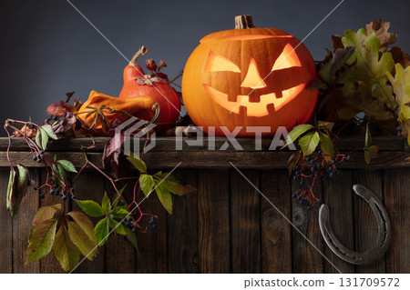 Halloween pumpkin lantern with dried-up leaves. 131709572