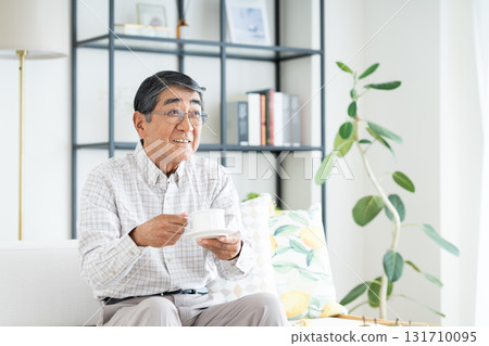 Senior man drinking coffee in the living room 131710095