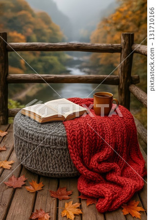 Cozy autumn reading scene with book mug and red knit blanket on deck Cozy autumn reading scene with book mug and red knit blanket on deck 131710166