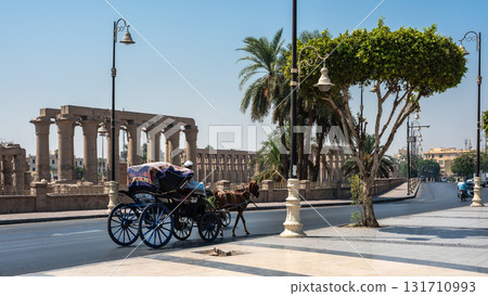 Horse-Drawn Carriage in Front of Ancient Luxor Temple Horse-Drawn Carriage in Front of Ancient Luxor Temple 131710993
