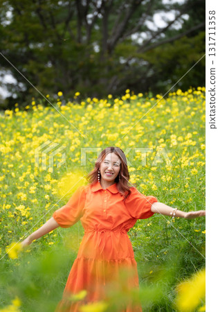 Woman taking a walk in a rape field Woman taking a walk in a rape field 131711358