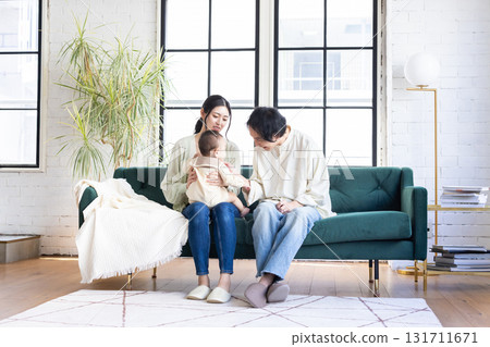 微笑的年輕家庭在客廳放鬆 131711671