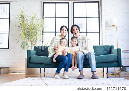 微笑的年輕家庭在客廳放鬆 131711678