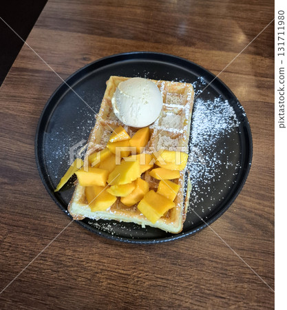 Belgian waffle with fresh mango and vanilla ice cream Belgian waffle with fresh mango and vanilla ice cream 131711980