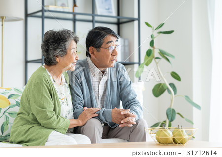 Senior couple relaxing in the living room Senior couple relaxing in the living room 131712614