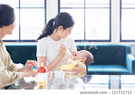 A couple feeding their baby food A couple feeding their baby food 131712752