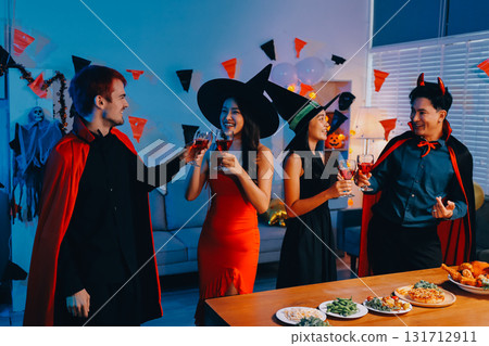 Joyful office Halloween party with coworkers in costumes, celebrating with drinks and laughter, fostering teamwork and festive spirit 131712911