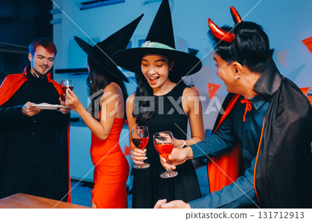 Joyful office Halloween party with coworkers in costumes, celebrating with drinks and laughter, fostering teamwork and festive spirit 131712913