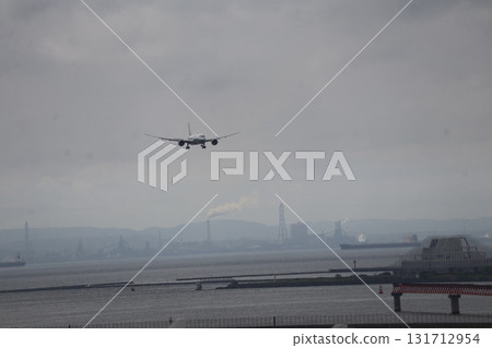 準備降落的飛機、朦朧的天空、工業區、山脈和海 準備降落的飛機、朦朧的天空、工業區、山脈和海 131712954