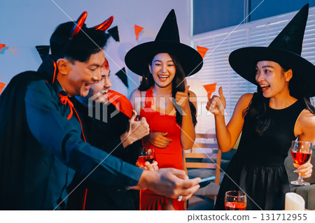 Joyful office Halloween party with coworkers in costumes, celebrating with drinks and laughter, fostering teamwork and festive spirit 131712955