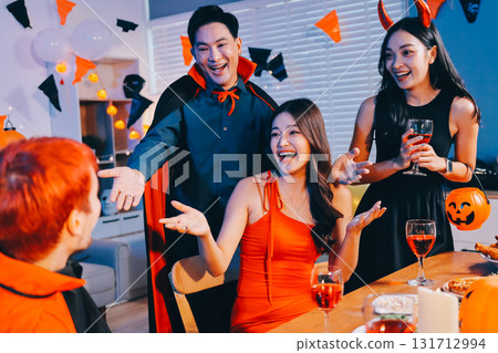 Joyful office Halloween party with coworkers in costumes, celebrating with drinks and laughter, fostering teamwork and festive spirit 131712994