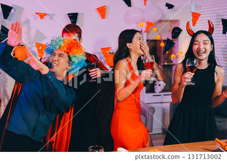 Joyful office Halloween party with coworkers in costumes, celebrating with drinks and laughter, fostering teamwork and festive spirit 131713002