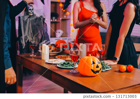 Joyful office Halloween party with coworkers in costumes, celebrating with drinks and laughter, fostering teamwork and festive spirit 131713003