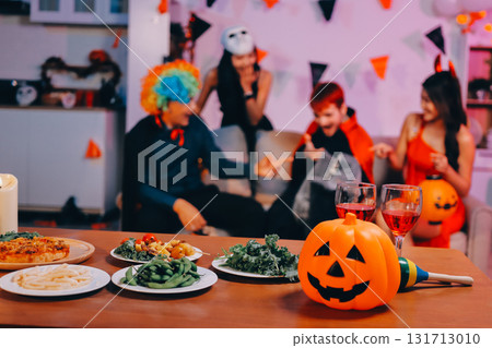 Joyful office Halloween party with coworkers in costumes, celebrating with drinks and laughter, fostering teamwork and festive spirit 131713010