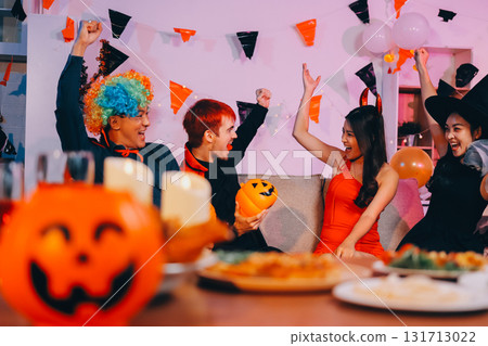 Joyful office Halloween party with coworkers in costumes, celebrating with drinks and laughter, fostering teamwork and festive spirit 131713022