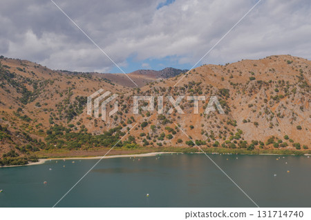 Hidden mountain lake with calm turquoise water red rocks and green trees. 131714740