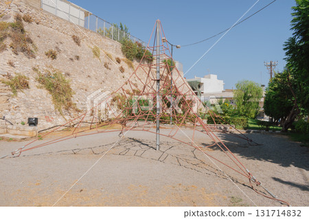 Playground climbing structure in city park shaped like pyramid. 131714832