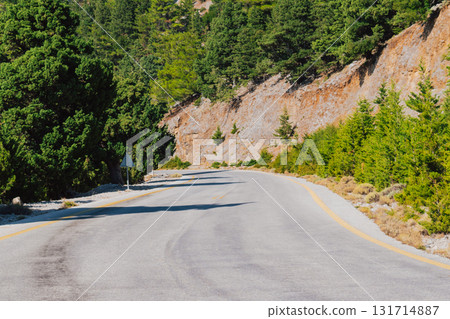 Mountain road section in Crete near Omalos in White Mountains with pine trees. Mountain road section in Crete near Omalos in White Mountains with pine trees. 131714887
