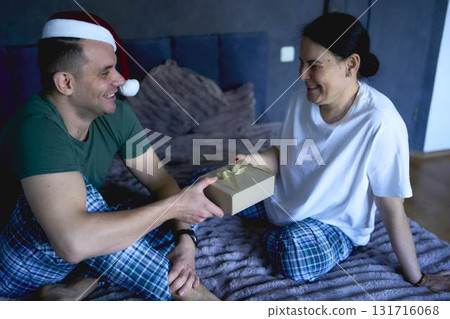 senior woman and young man exchange New Year's gifts, gift certificates, celebration at home senior woman and young man exchange New Year's gifts, gift certificates, celebration at home 131716068