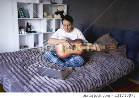 a senior woman learns to play the guitar with online lessons a senior woman learns to play the guitar with online lessons 131716075