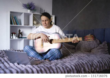 a senior woman learns to play the guitar with online lessons a senior woman learns to play the guitar with online lessons 131716076