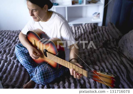 a senior woman learns to play the guitar with online lessons a senior woman learns to play the guitar with online lessons 131716078