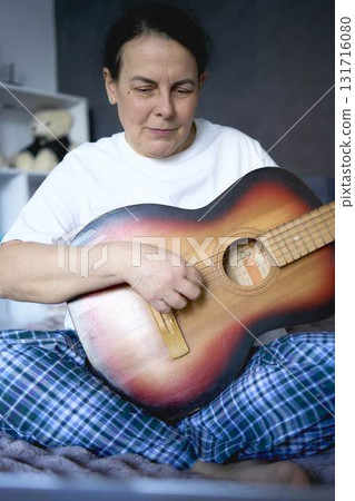 a senior woman learns to play the guitar with online lessons a senior woman learns to play the guitar with online lessons 131716080