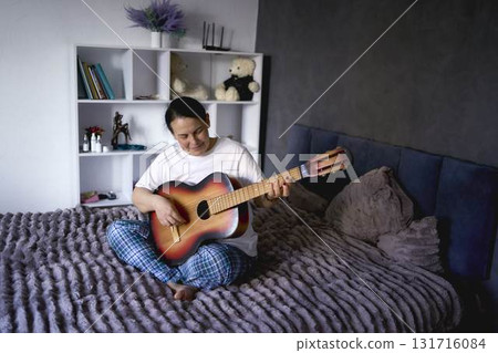 a senior woman learns to play the guitar with online lessons a senior woman learns to play the guitar with online lessons 131716084