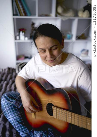 a senior woman learns to play the guitar with online lessons a senior woman learns to play the guitar with online lessons 131716085