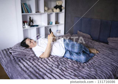 a senior woman chatting on the phone in bed a senior woman chatting on the phone in bed 131716086